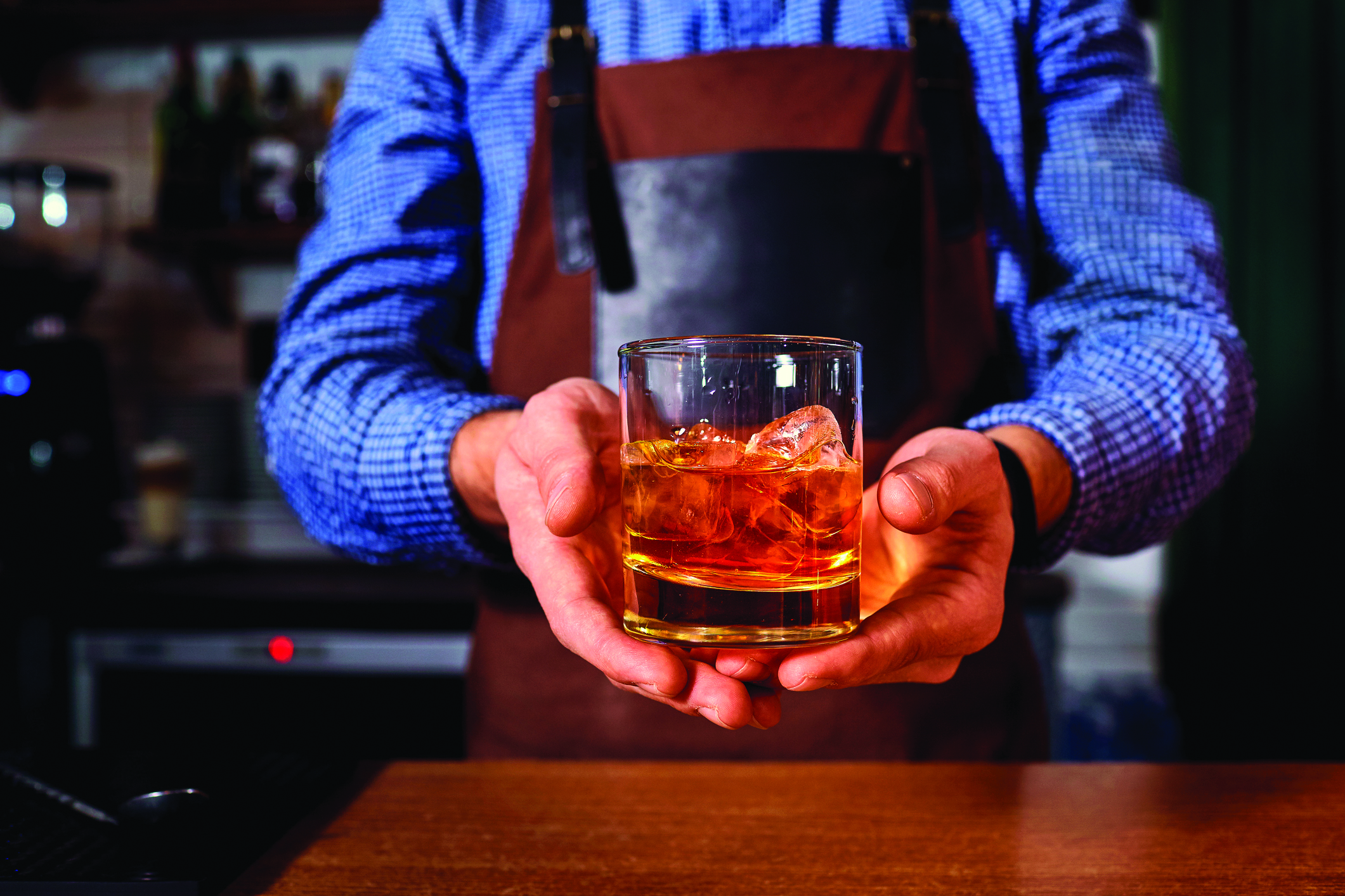 Bartender serving a glass of whiskey