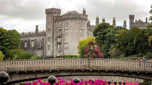 The exterior of Kilkenny Castle with its large round tower, taken from across the River Nore.